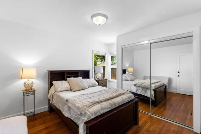 a bedroom with a bed and wooden floor