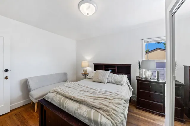 a bedroom with a bed and wooden floor