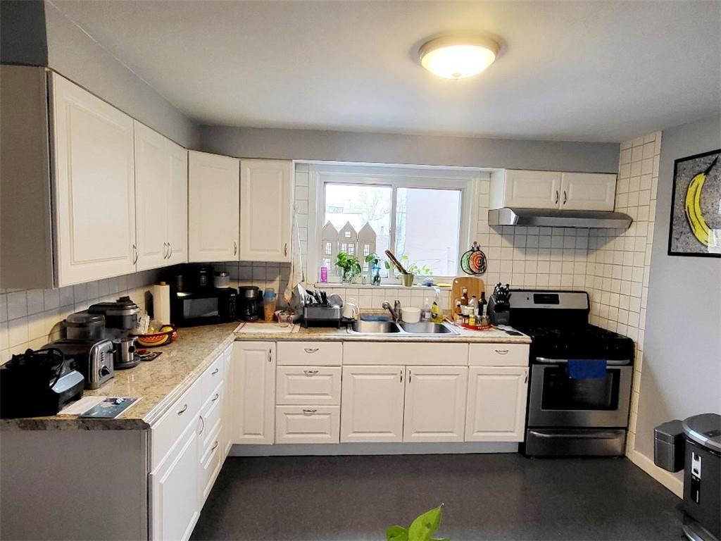 609 Ovington Avenue Brooklyn, NY 11209 - Photo 3 of 11 a kitchen with a sink dishwasher stove and white cabinets