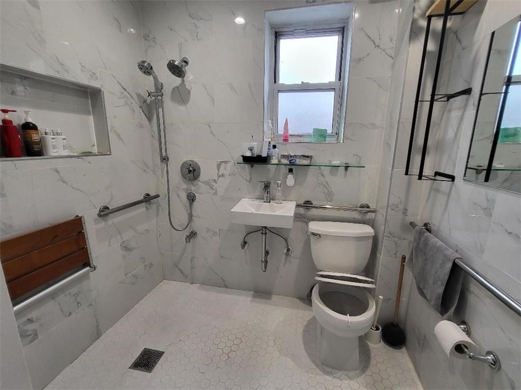 609 Ovington Avenue Brooklyn, NY 11209 - Photo 4 of 11 a bathroom with a sink toilet and mirror