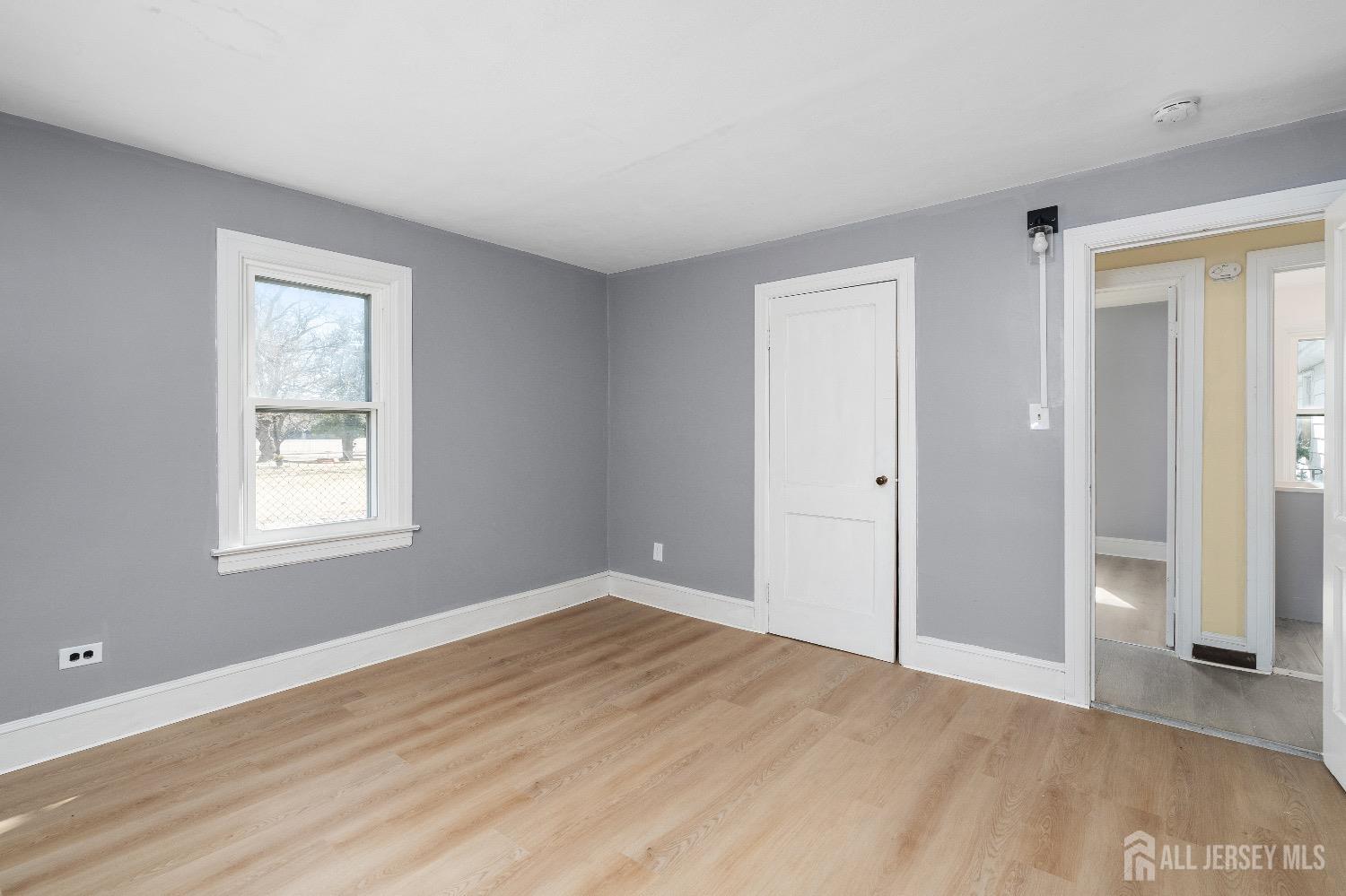 225 Kuser Road Hamilton, NJ 08619 - Photo 17 of 26 a view of an empty room with wooden floor and a window