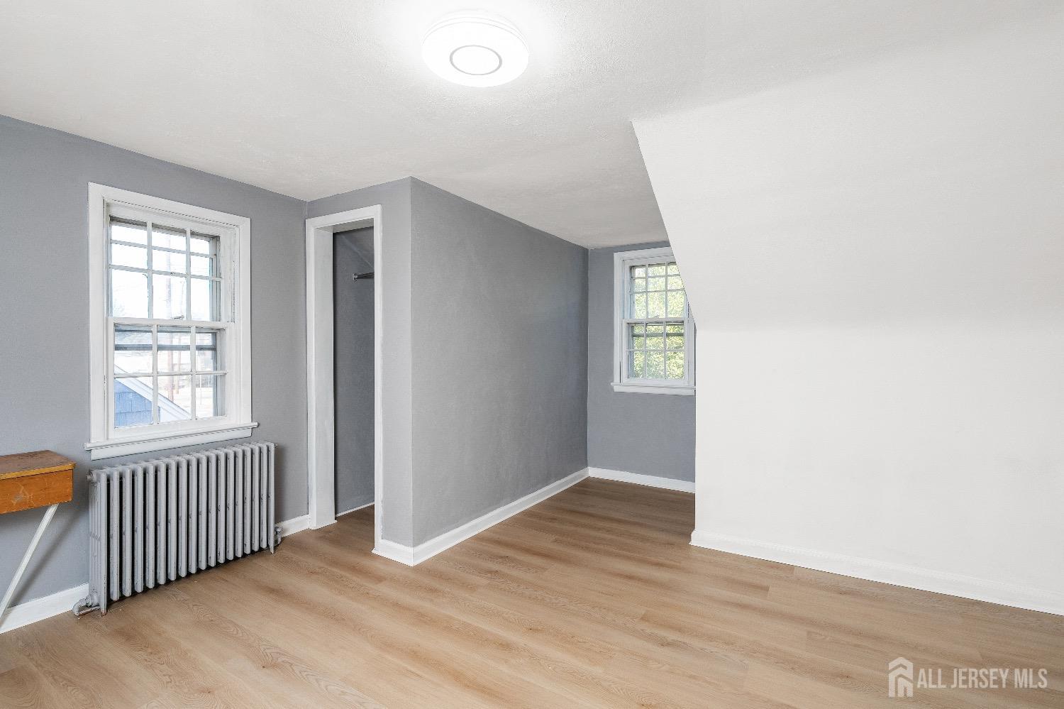 225 Kuser Road Hamilton, NJ 08619 - Photo 19 of 26 an empty room with wooden floor and windows