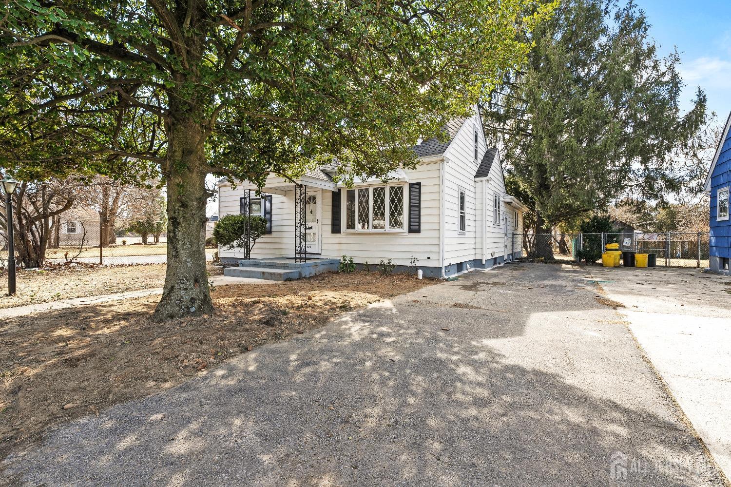 225 Kuser Road Hamilton, NJ 08619 - Photo 3 of 26 a front view of a house with a yard and large trees
