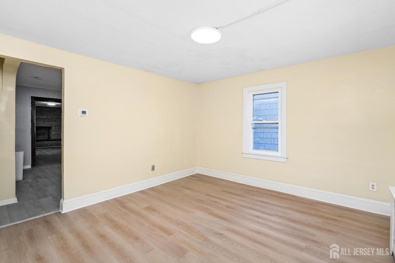 225 Kuser Road Hamilton, NJ 08619 - Photo 4 of 26 an empty room with wooden floor and windows