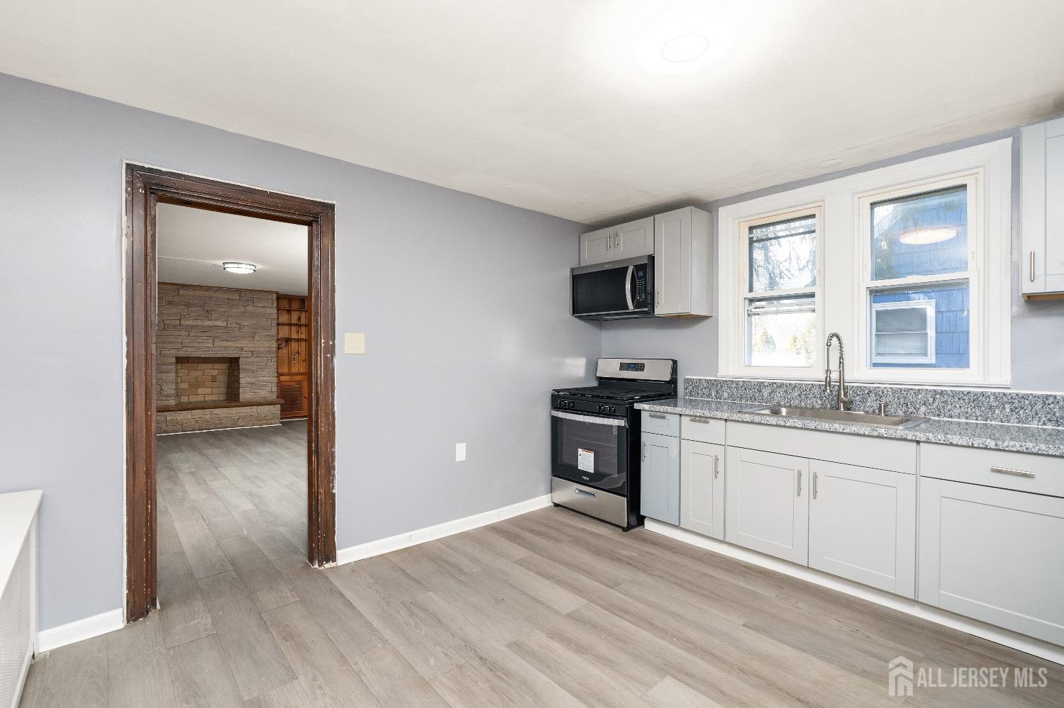 225 Kuser Road Hamilton, NJ 08619 - Photo 6 of 26 a kitchen with granite countertop a stove top oven and sink