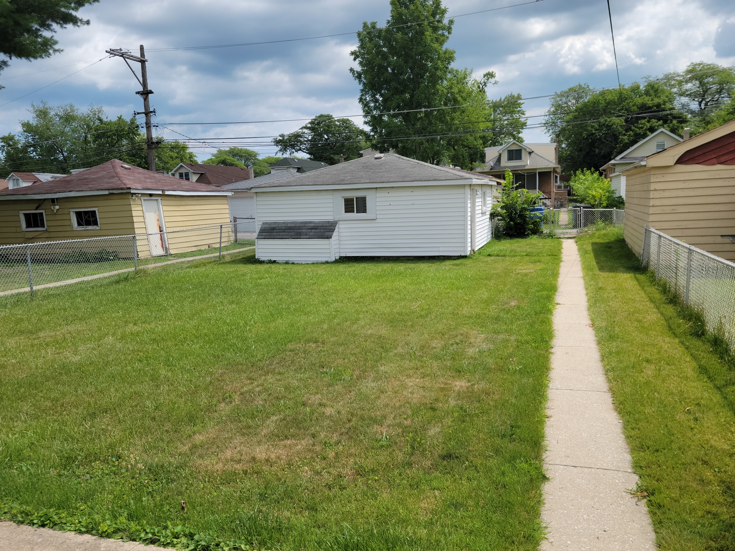 8529 South Rhodes Avenue Chicago, IL 60619 - Photo 14 of 16 a front view of a house with a yard