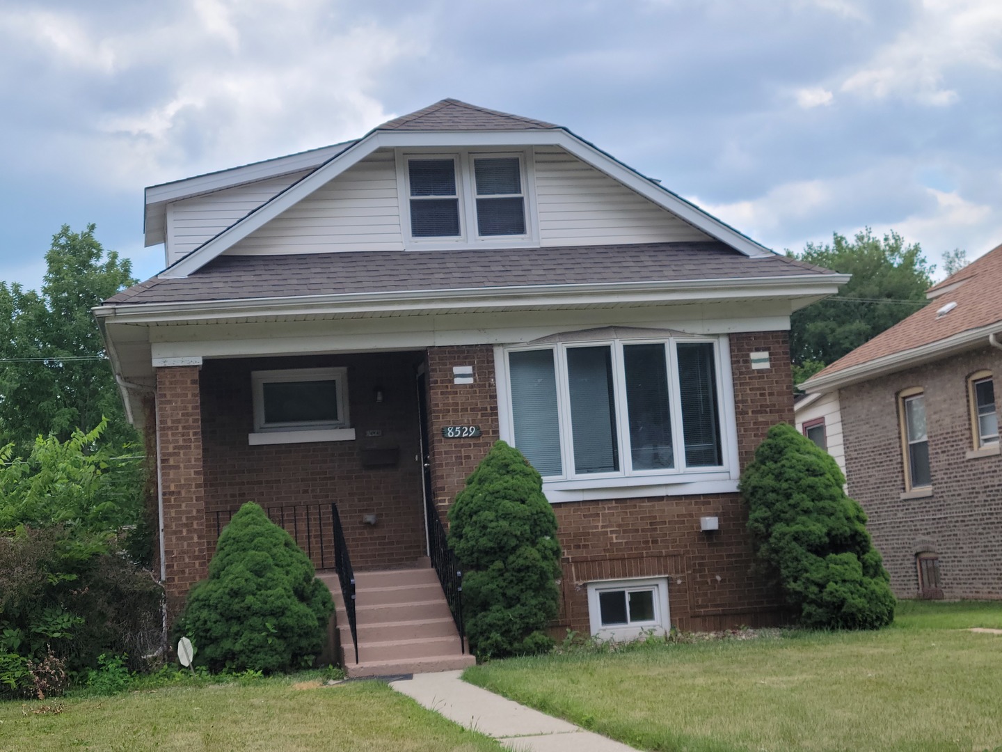8529 South Rhodes Avenue Chicago, IL 60619 - Photo 2 of 16 a front view of a house with garden