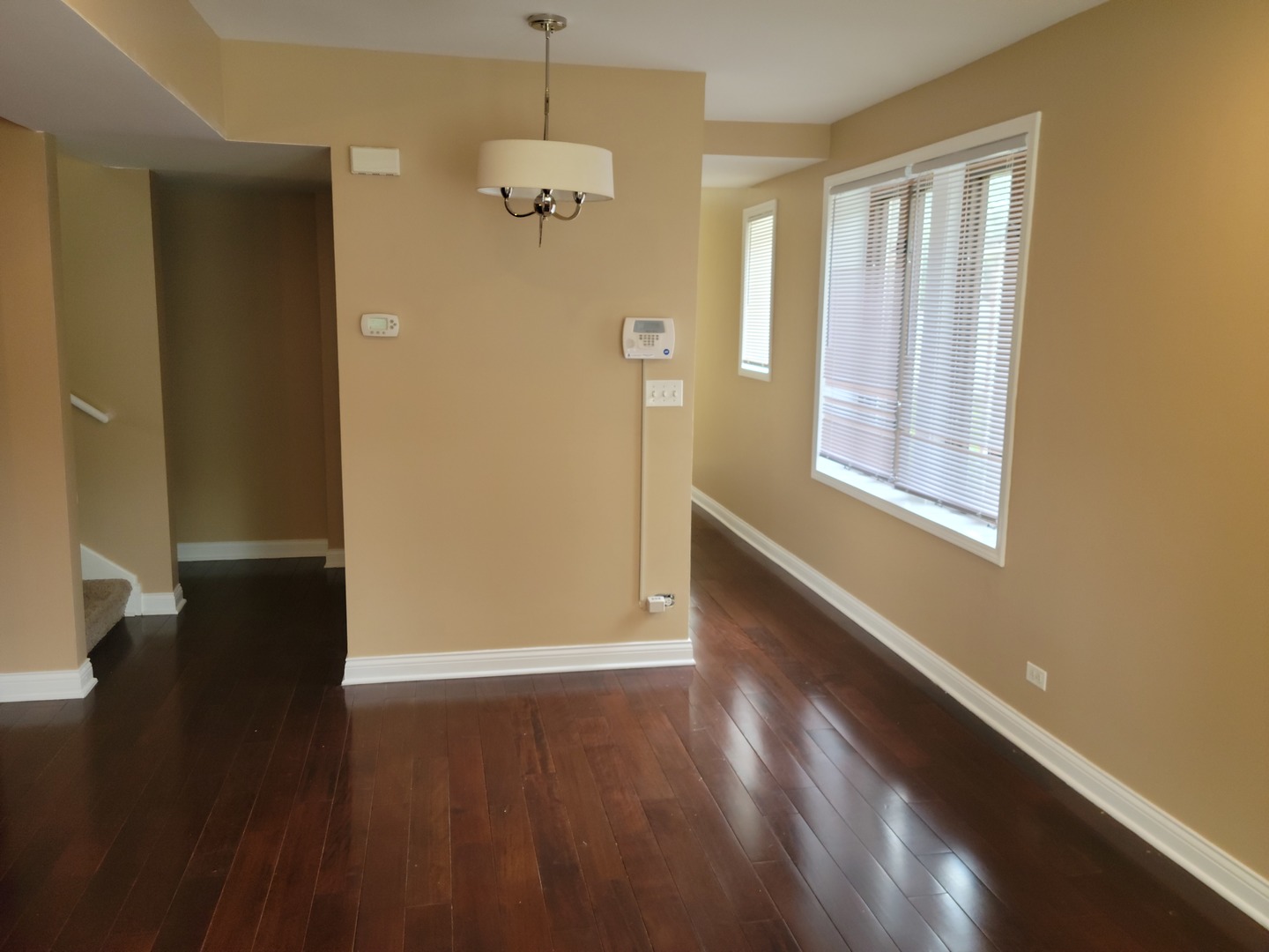 8529 South Rhodes Avenue Chicago, IL 60619 - Photo 3 of 16 an empty room with wooden floor and windows