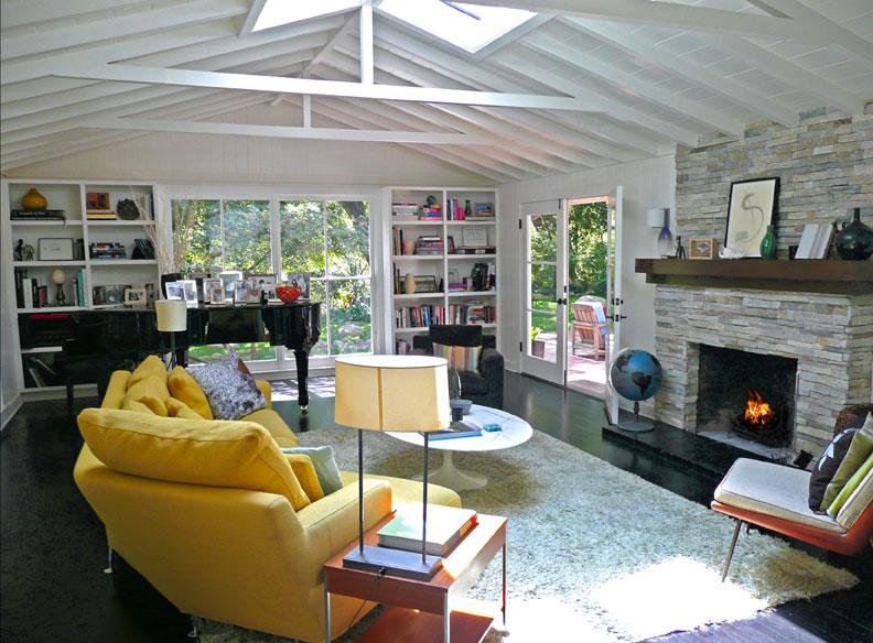 a living room with furniture a fireplace and a large window