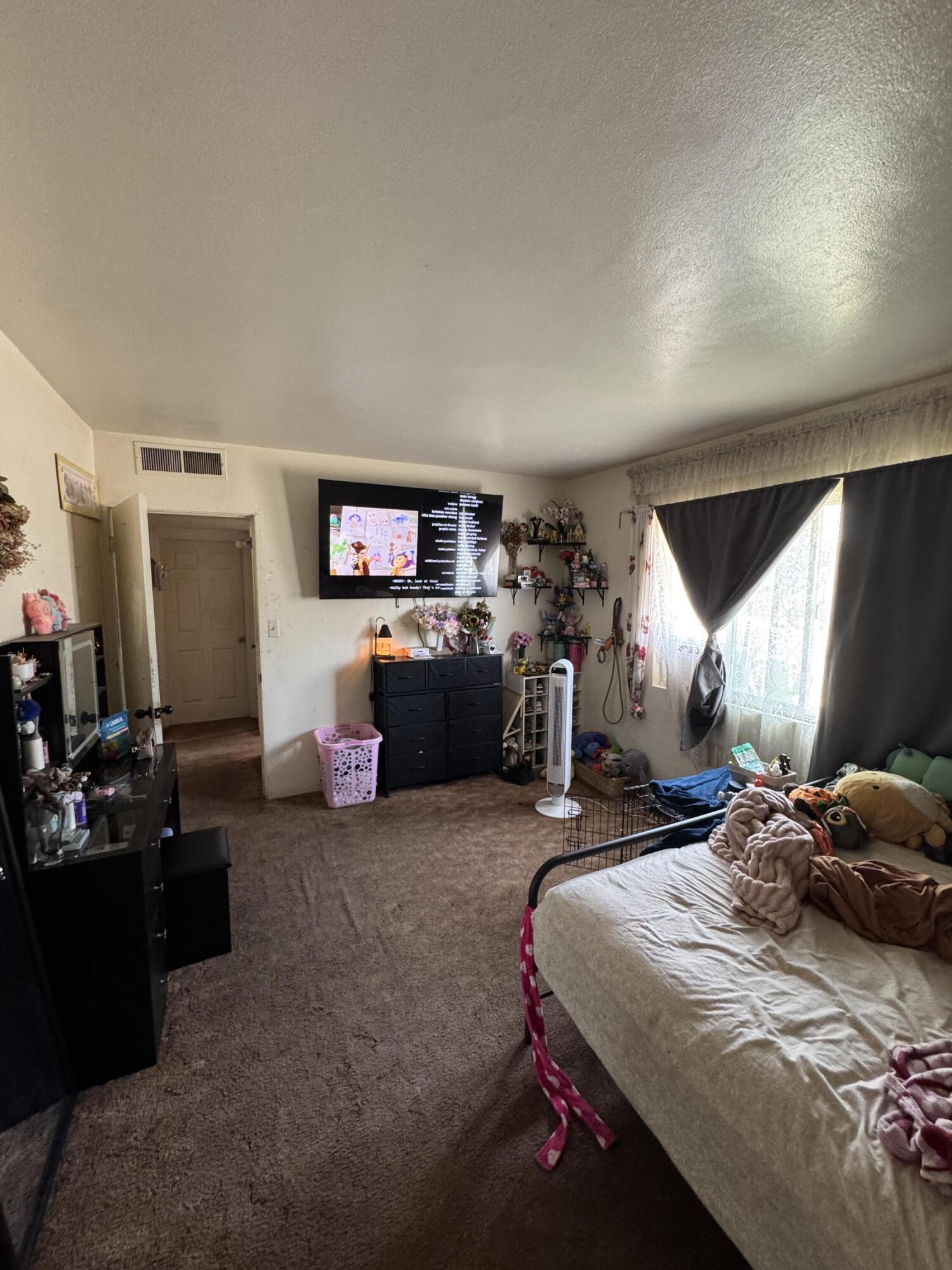 704 North Floral Street Visalia, CA 93291 - Photo 23 of 51 a bedroom with a bed gym equipment and a large window