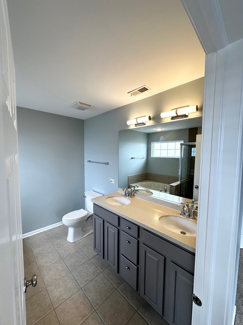 4110 Bethlehem Road Aurora, IL 60504 - Photo 37 of 53 a bathroom with a granite countertop sink a toilet and a mirror