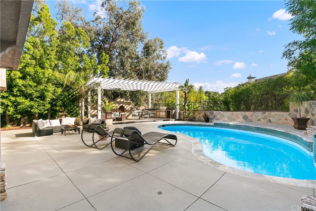 10282 Ambervale Lane North Tustin, CA 92705 - Photo 43 of 50 a view of a swimming pool with lawn chairs under an umbrella
