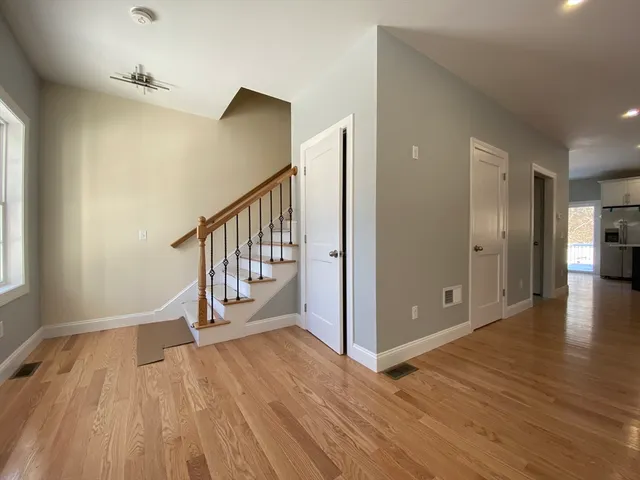 an empty room with ceiling fan and window