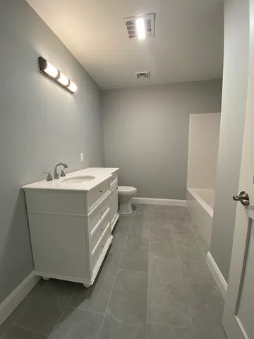 a bathroom with a sink a toilet and a window