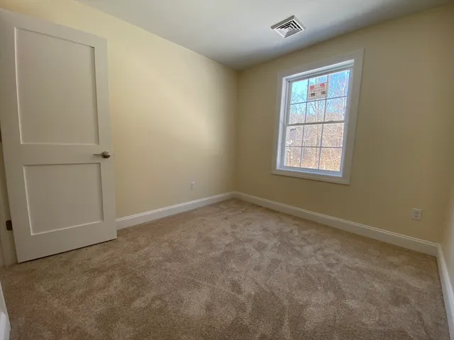 an empty room with a window and a ceiling fan