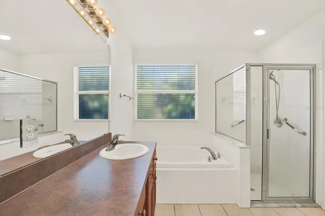 a bathroom with a tub sink and mirror