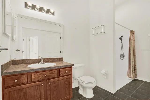 a bathroom with a granite countertop sink toilet and shower