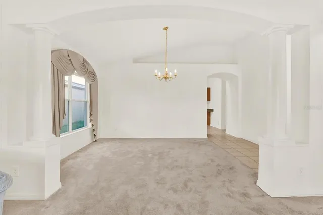 a view of a hallway with windows and chandelier