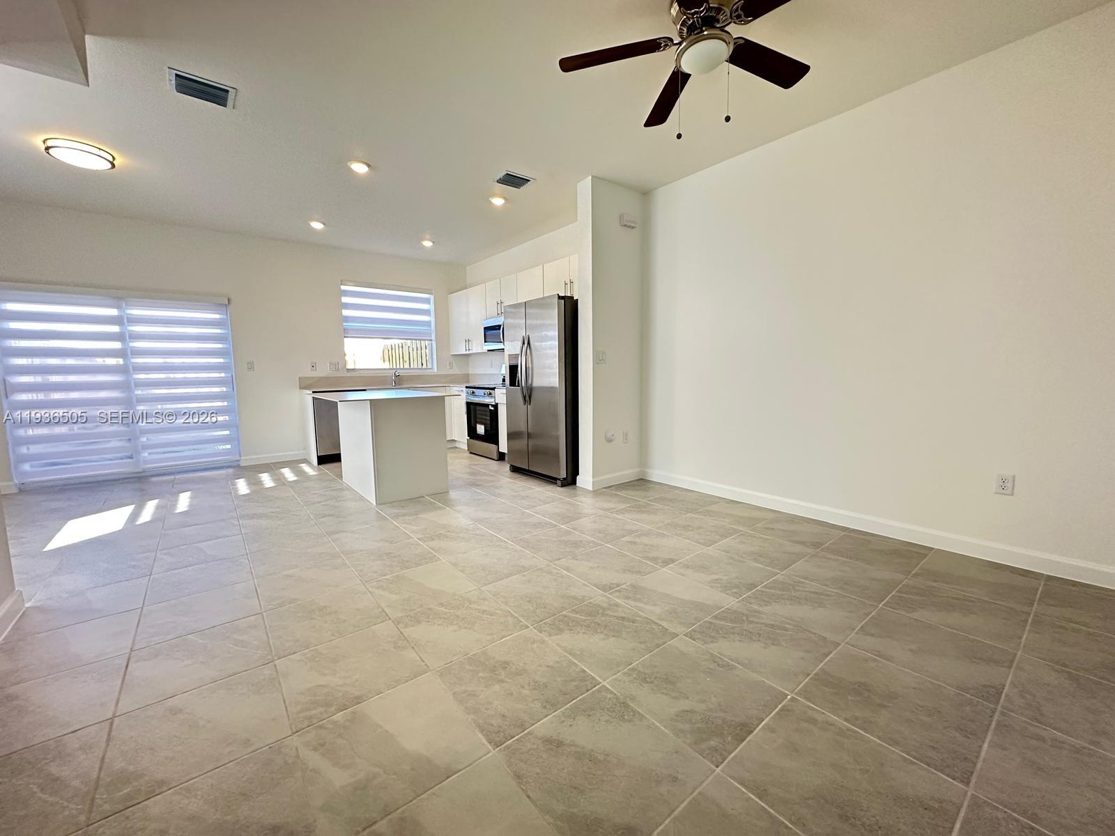 26848 Southwest 121st Avenue Homestead, FL 33032 - Photo 3 of 9 a view of a kitchen with furniture and a ceiling fan