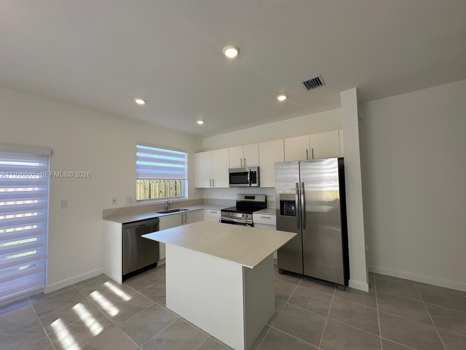 26848 Southwest 121st Avenue Homestead, FL 33032 - Photo 4 of 9 a kitchen with stainless steel appliances a refrigerator sink and stove