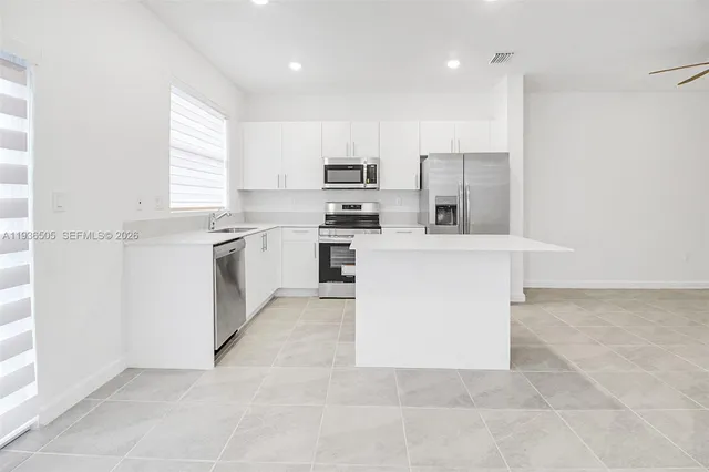 a large kitchen with cabinets and stainless steel appliances
