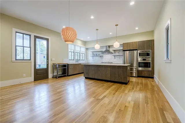 a large kitchen with cabinets wooden floor and stainless steel appliances