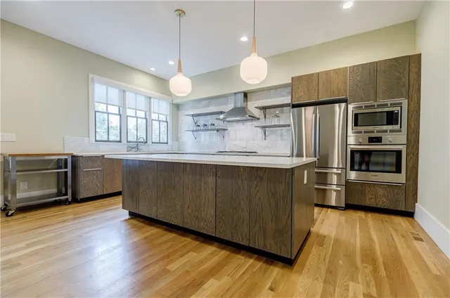 a kitchen with stainless steel appliances wooden floors and wooden cabinets