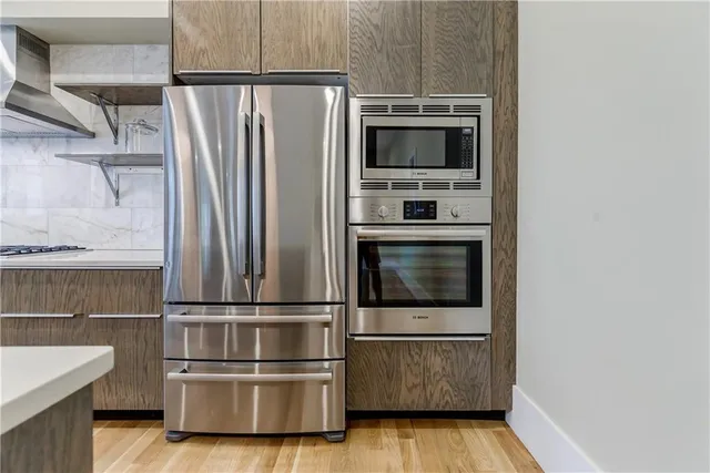 a kitchen with kitchen island wooden floor and stainless steel appliances