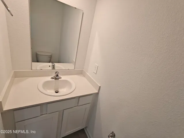 a bathroom with a sink toilet and a mirror