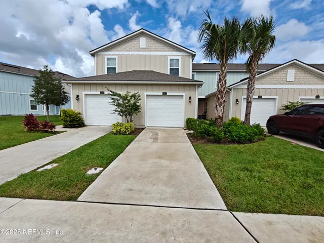 a front view of a house with a yard and garage