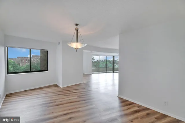a view of an empty room with wooden floor