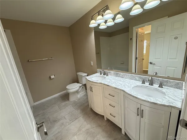 a bathroom with a granite countertop sink a toilet and a mirror