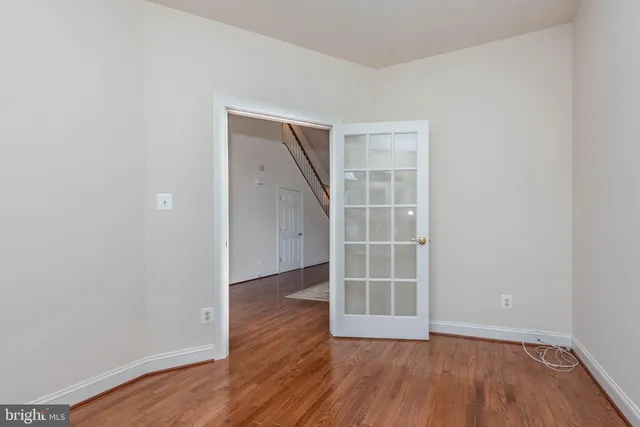 a kitchen with stainless steel appliances granite countertop a refrigerator a stove a sink a dining table and chairs with wooden floor