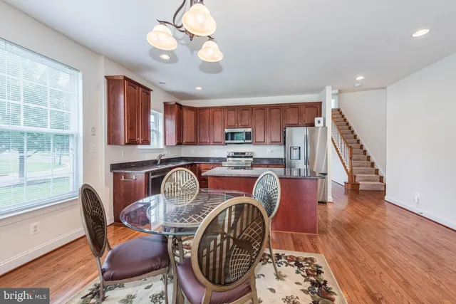 a kitchen with stainless steel appliances granite countertop a stove a sink dishwasher a refrigerator and a microwave