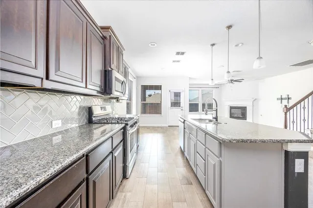 a kitchen with stainless steel appliances granite countertop a sink and cabinets