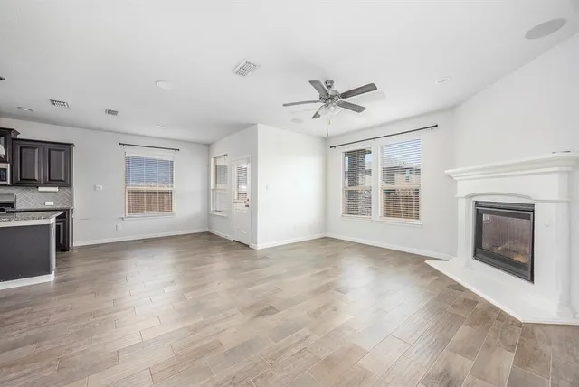 a view of an empty room with a fireplace and a window