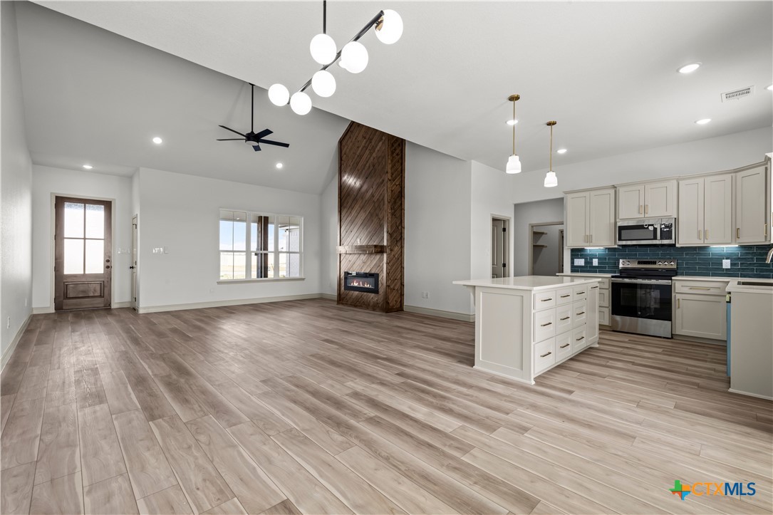 1835 Ember Drive Temple, TX 76502 - Photo 5 of 44 a large kitchen with stainless steel appliances granite countertop a refrigerator a stove oven a sink dishwasher and white cabinets with wooden floor