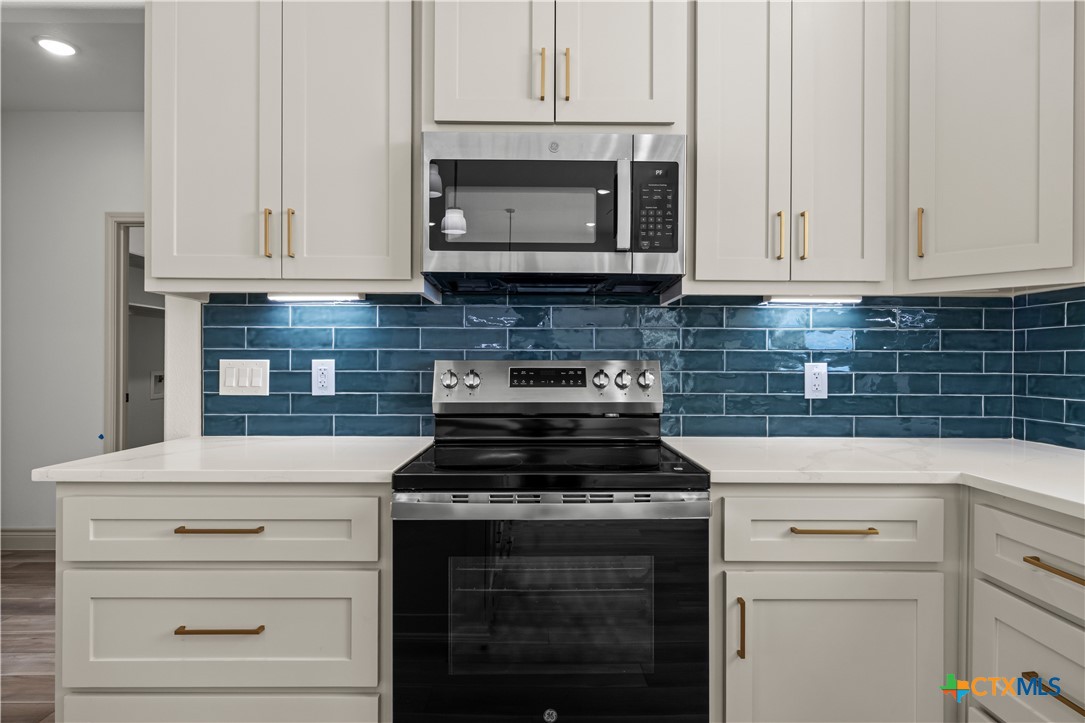 1835 Ember Drive Temple, TX 76502 - Photo 6 of 44 a kitchen with granite countertop white cabinets and stainless steel appliances