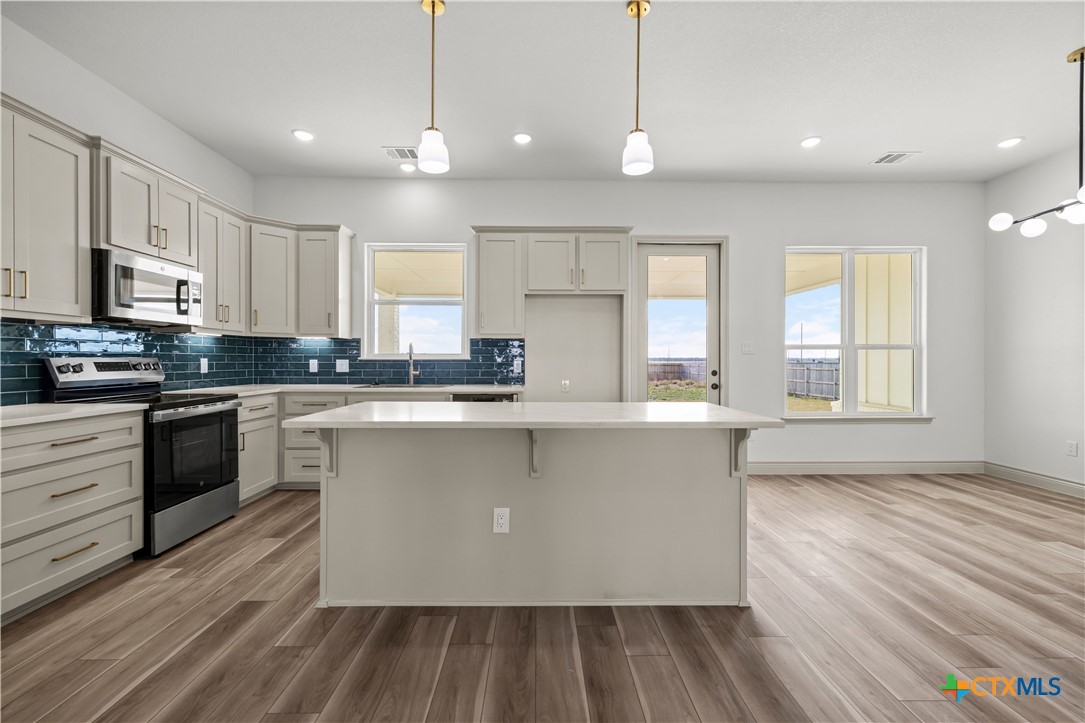 1835 Ember Drive Temple, TX 76502 - Photo 10 of 44 a kitchen with stainless steel appliances granite countertop a stove a sink and a refrigerator