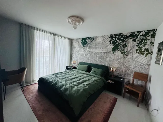 a bedroom with bed and a chair