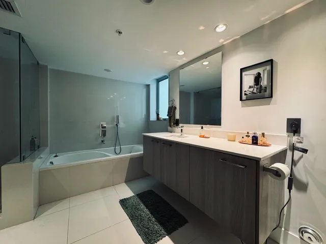 a bathroom with a tub a sink and mirror
