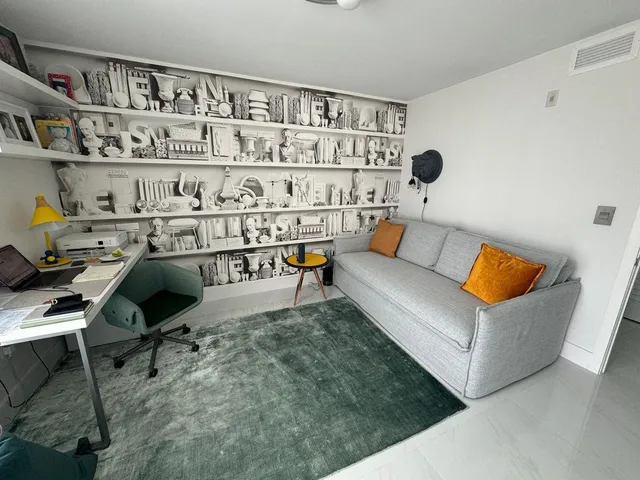 a living room with furniture and a book shelf