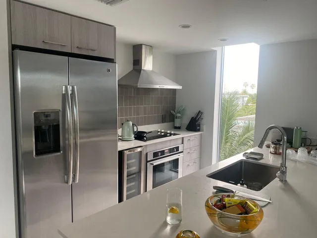 a kitchen with a refrigerator and a stove top oven