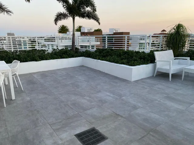 a view of a patio with table and chairs potted plants and palm trees