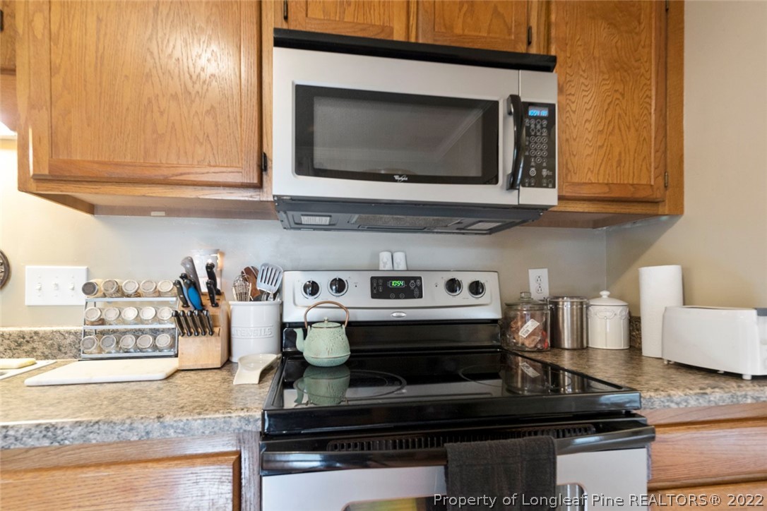 114 Windsor Lane Raeford, NC 28376 - Photo 16 of 32 a kitchen with stainless steel appliances granite countertop a stove and a microwave