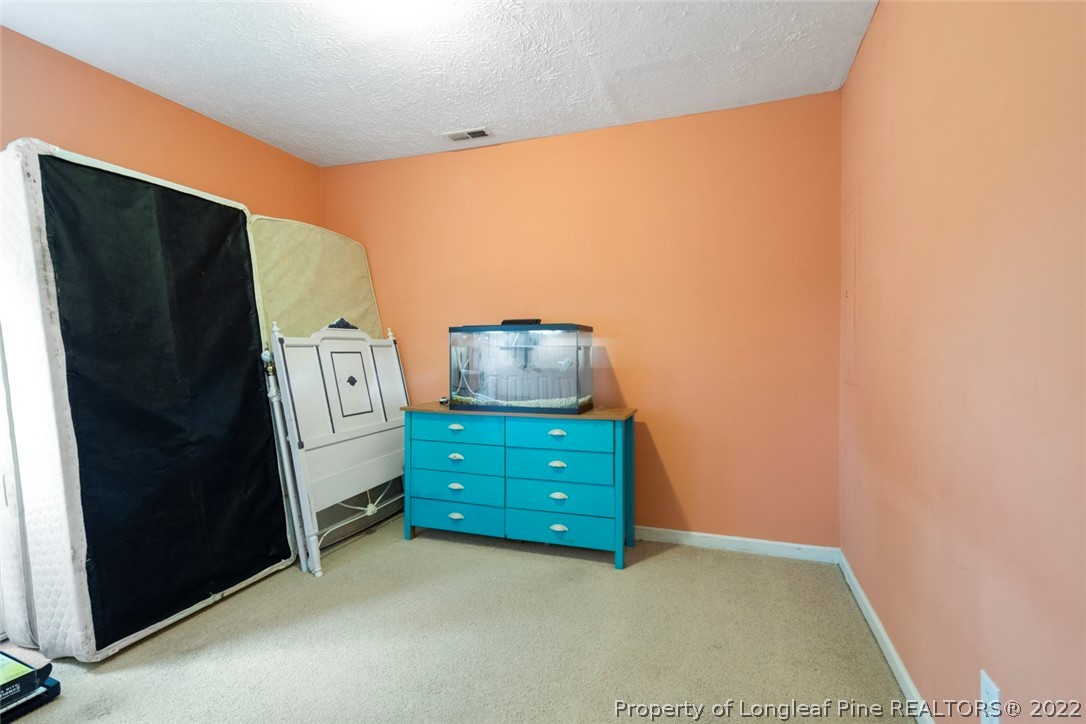 114 Windsor Lane Raeford, NC 28376 - Photo 17 of 32 a room with a dresser and mirror