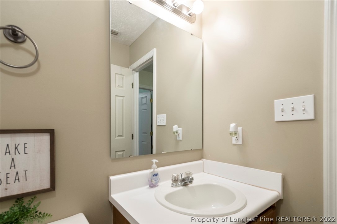 114 Windsor Lane Raeford, NC 28376 - Photo 20 of 32 a bathroom with a toilet a sink and mirror
