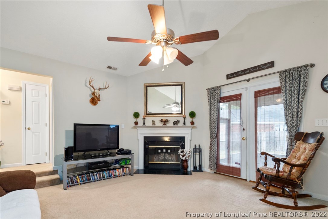 114 Windsor Lane Raeford, NC 28376 - Photo 8 of 32 a living room with furniture a fireplace and a flat screen tv
