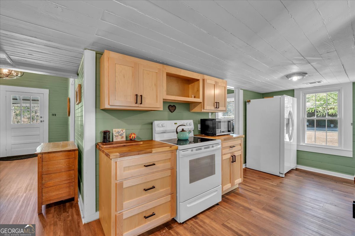 3613 S Highway Dublin, GA 31021 - Photo 14 of 52 a kitchen with stainless steel appliances granite countertop a stove a refrigerator a sink dishwasher and white cabinets with wooden floor