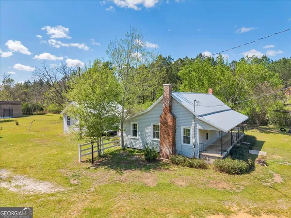 a view of a house with a small yard and wooden fence